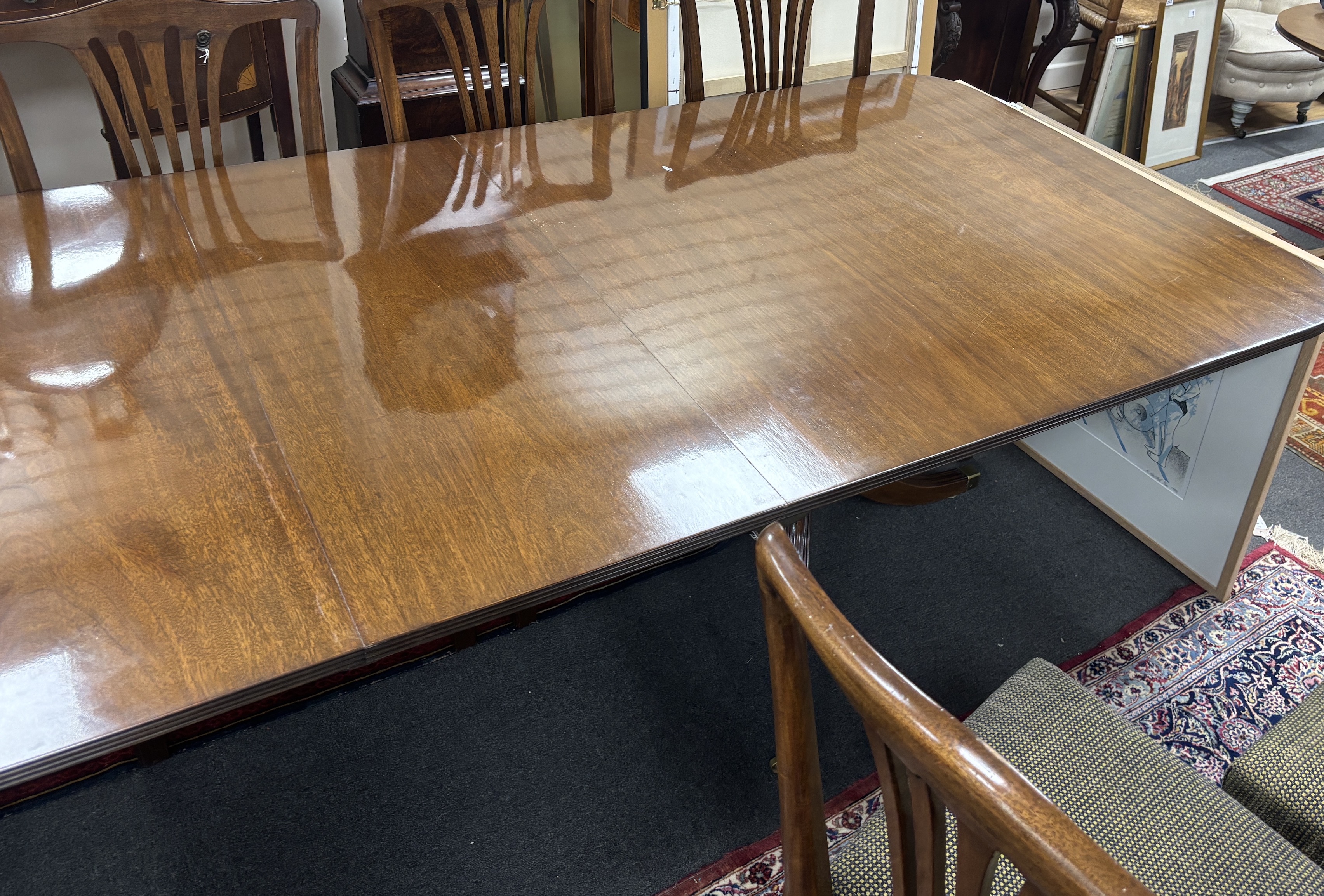 A reproduction George III style mahogany twin pillar extending dining table, 304cm extended, two spare leaves, depth 107cm, height 72cm